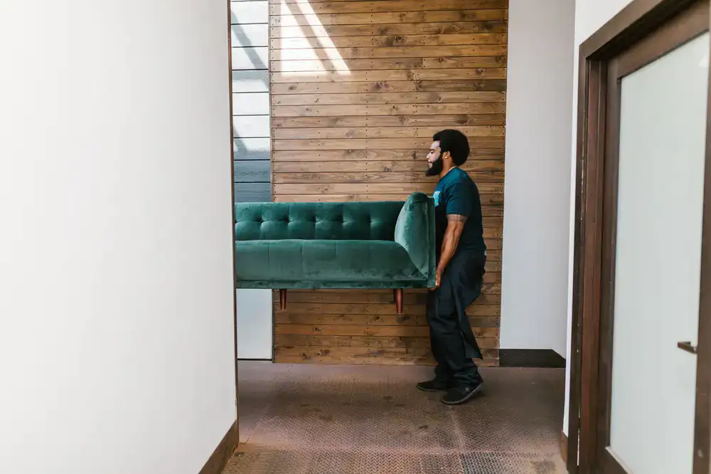 Movers carefully carrying a wrapped sofa